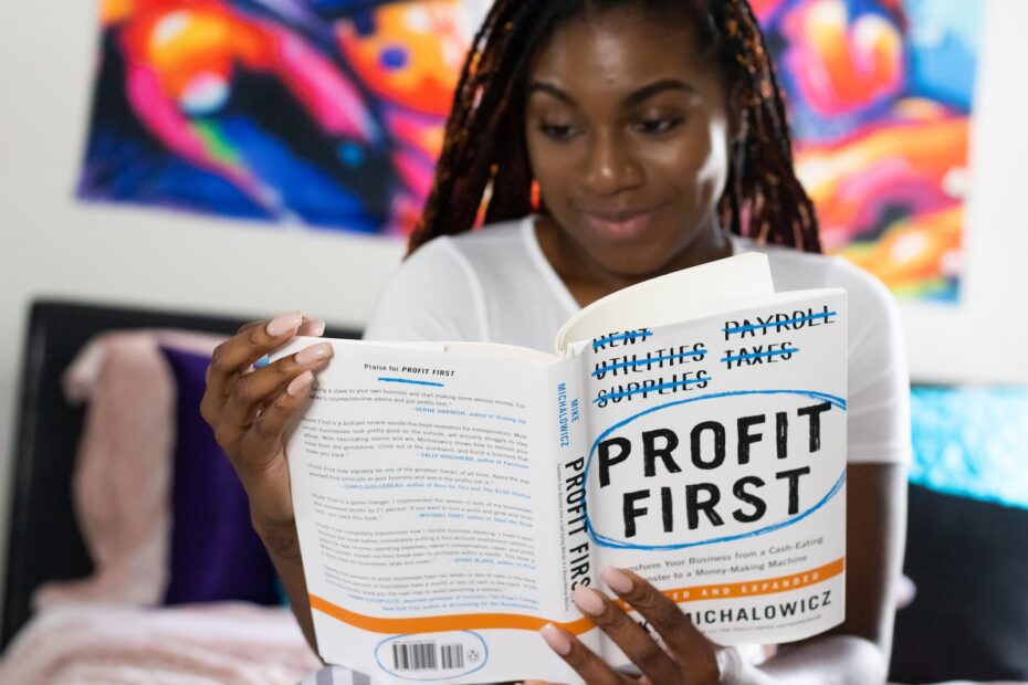 woman reading book on personal finance called profit first